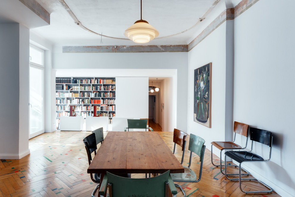 This is an example of a large scandi dining room in Berlin with white walls and light hardwood flooring.