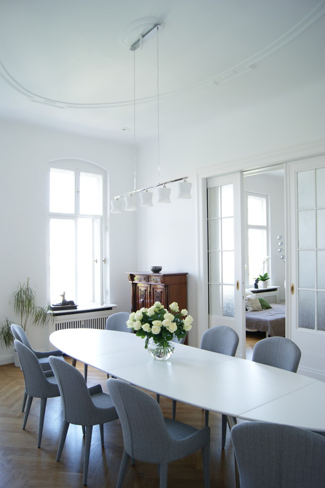 Cette image montre une salle à manger design de taille moyenne avec un mur blanc, parquet clair et aucune cheminée.