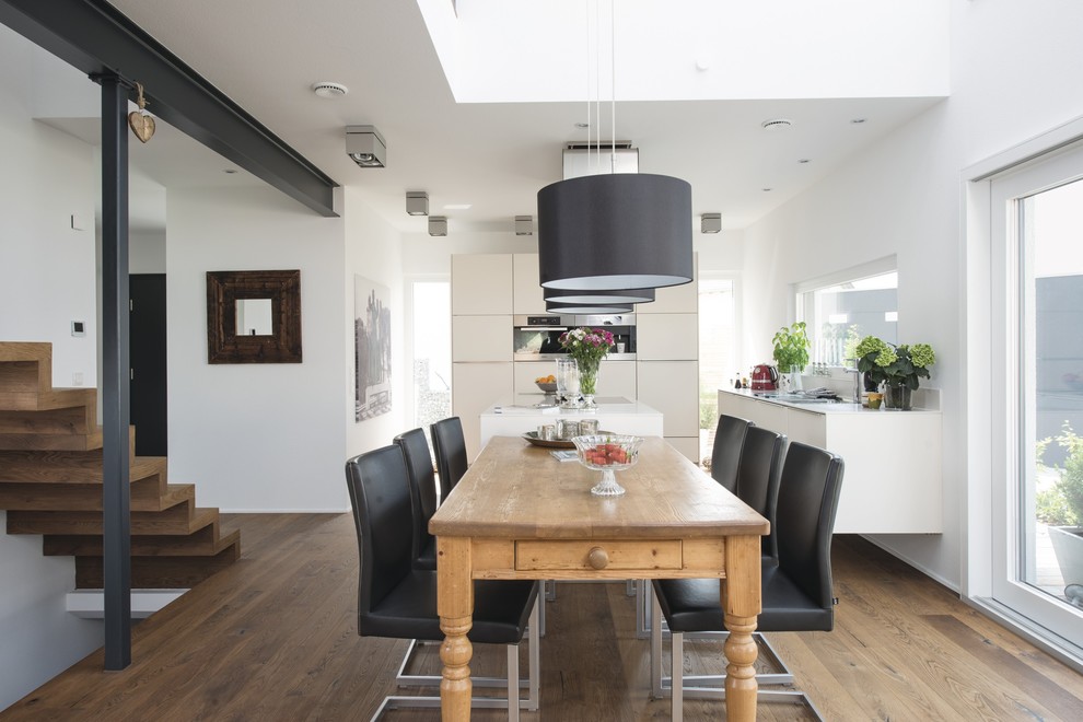 Esempio di una sala da pranzo aperta verso la cucina design con pareti bianche e pavimento in legno massello medio