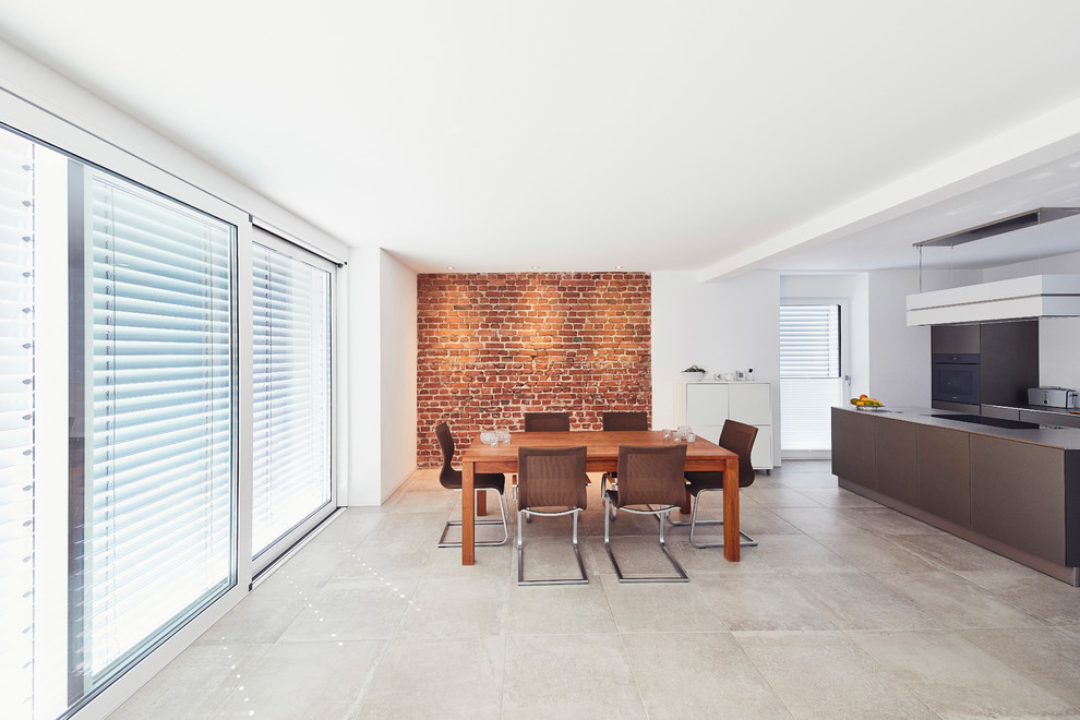 Imagen de comedor minimalista grande abierto con paredes blancas y suelo gris