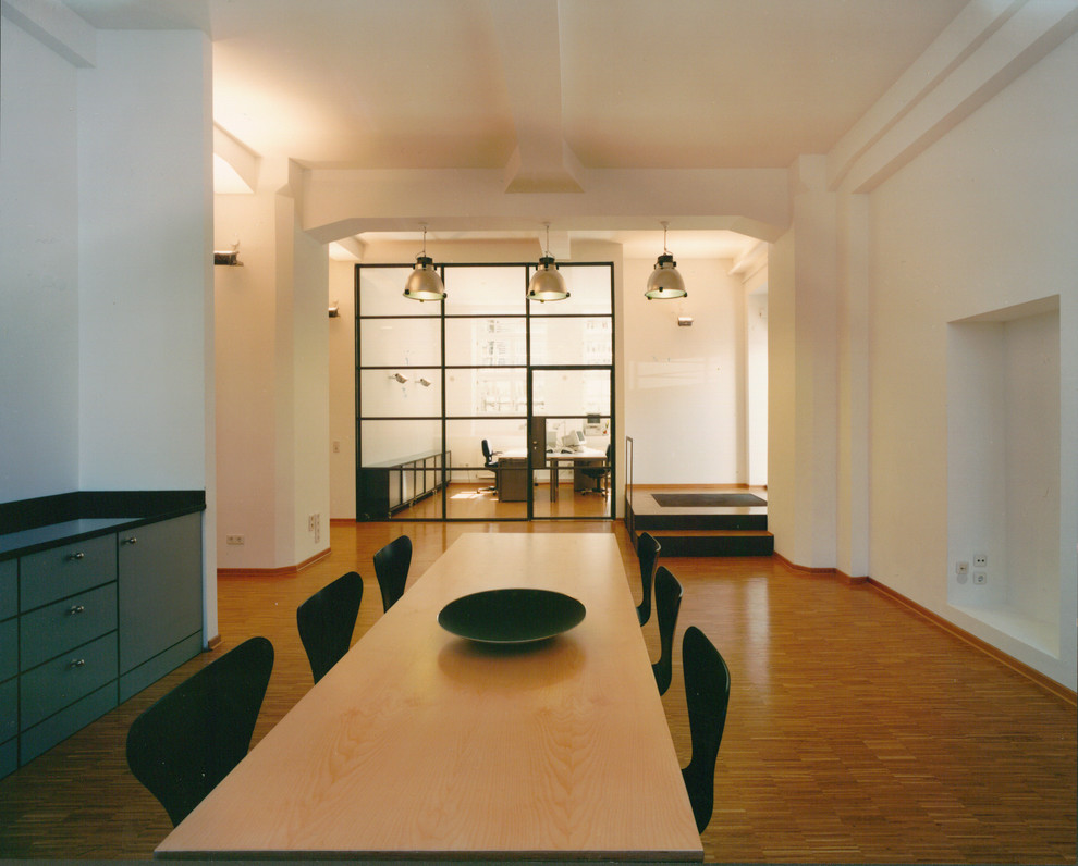 Esempio di un'ampia sala da pranzo minimalista con pareti bianche e pavimento in legno massello medio