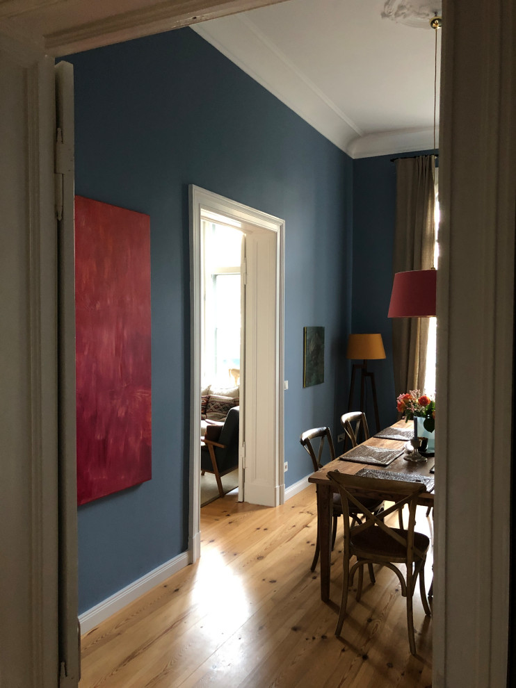 Imagen de comedor contemporáneo grande con paredes azules y suelo de madera clara