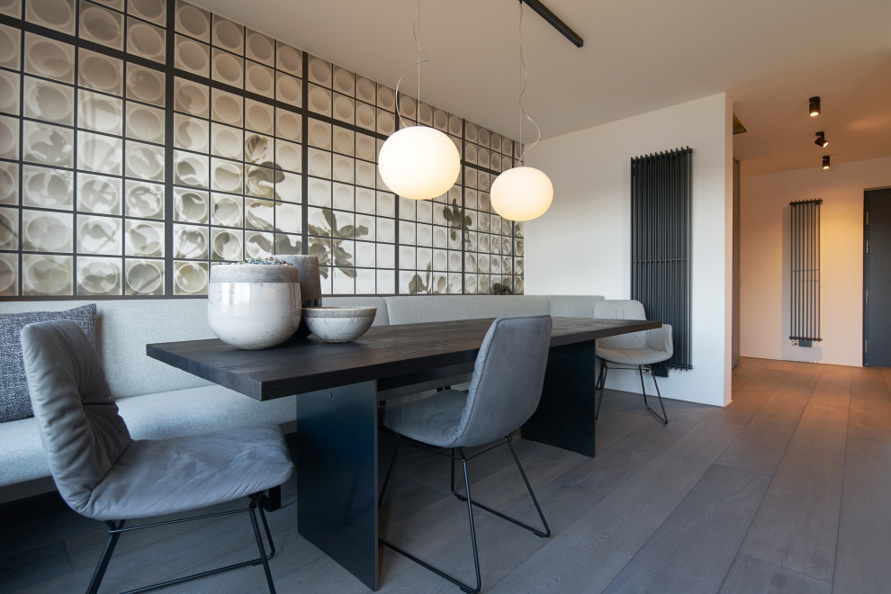 Mittelgroße Moderne Wohnküche ohne Kamin mit weißer Wandfarbe, dunklem Holzboden und braunem Boden in Düsseldorf