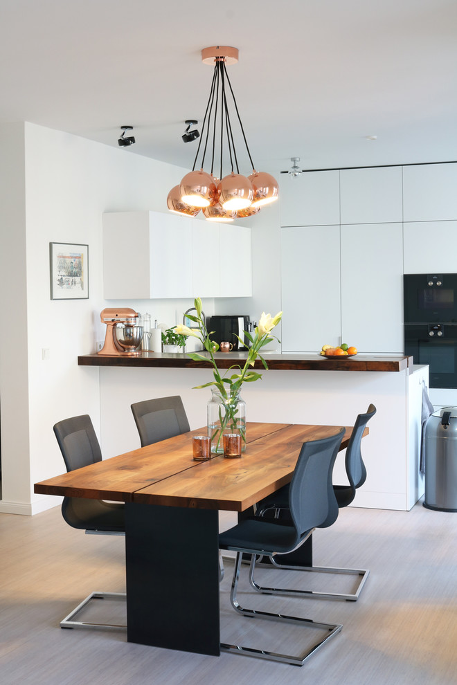 Свежая идея для дизайна: кухня-столовая среднего размера в современном стиле с белыми стенами, полом из бамбука и белым полом без камина - отличное фото интерьера