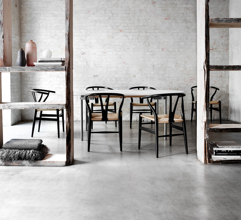 Ispirazione per una sala da pranzo minimal con pavimento in cemento