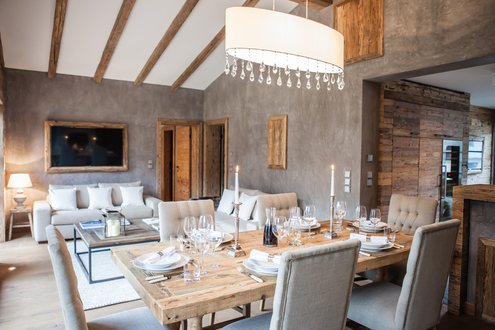 Exemple d'une salle à manger ouverte sur le salon montagne de taille moyenne avec un mur gris, un sol en bois brun et un sol marron.