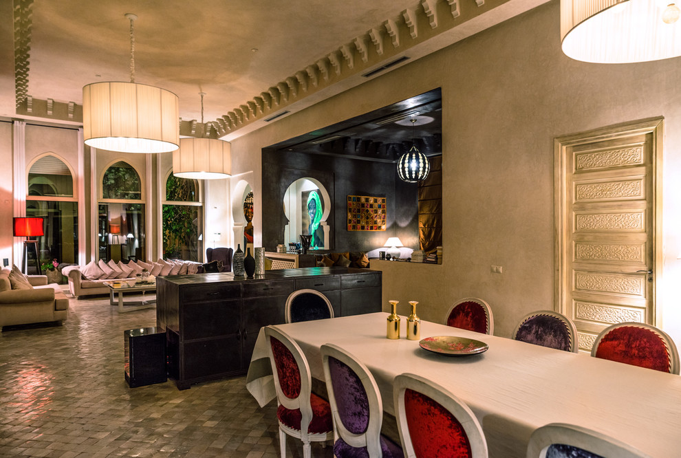 Idée de décoration pour une grande salle à manger ouverte sur le salon méditerranéenne avec un mur beige, tomettes au sol, aucune cheminée et un sol gris.
