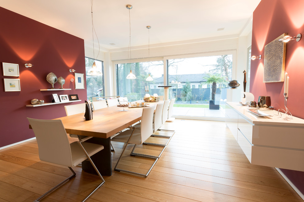 Idee per una grande sala da pranzo aperta verso il soggiorno contemporanea con pareti rosse, pavimento in legno massello medio e pavimento marrone