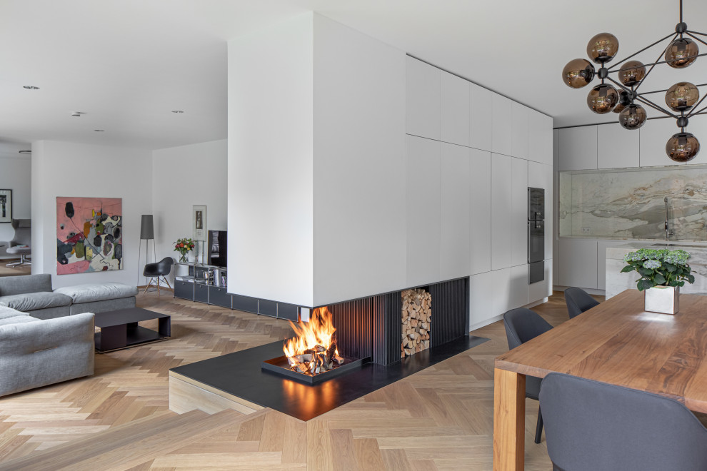 Offenes, Geräumiges Modernes Esszimmer mit weißer Wandfarbe, braunem Holzboden, Kaminofen und braunem Boden in München
