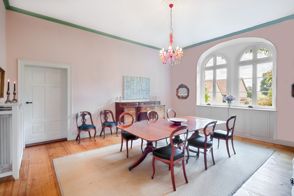 Esempio di una sala da pranzo boho chic chiusa e di medie dimensioni con pareti rosa, parquet scuro e pavimento marrone