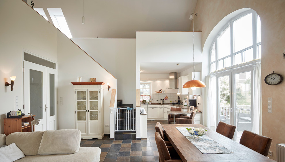 This is an example of an expansive country open plan dining room in Bremen with white walls and no fireplace.