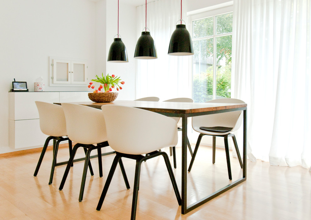 Foto di una sala da pranzo aperta verso la cucina minimal di medie dimensioni con pareti bianche, parquet chiaro, nessun camino e pavimento marrone