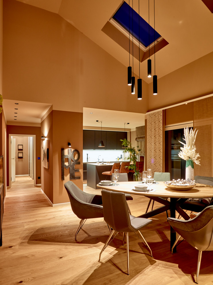 Idée de décoration pour une salle à manger design avec un sol en bois brun.
