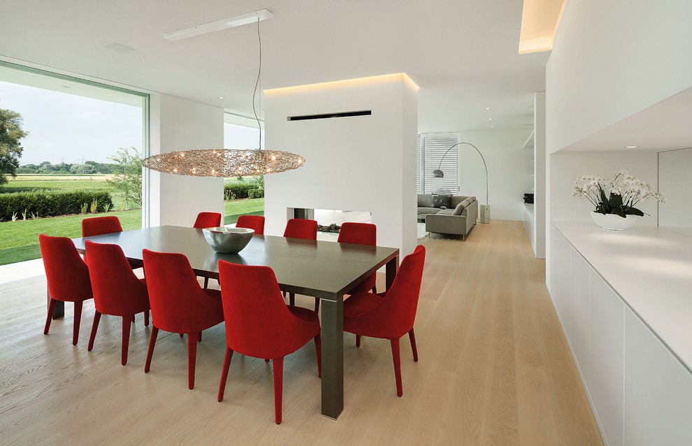 Источник вдохновения для домашнего уюта: столовая в современном стиле с белыми стенами, двусторонним камином и фасадом камина из штукатурки