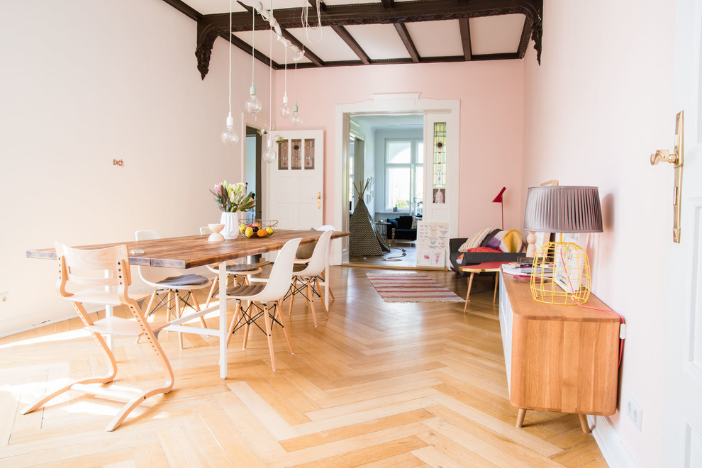 Immagine di una grande sala da pranzo eclettica chiusa con pareti rosa e parquet chiaro