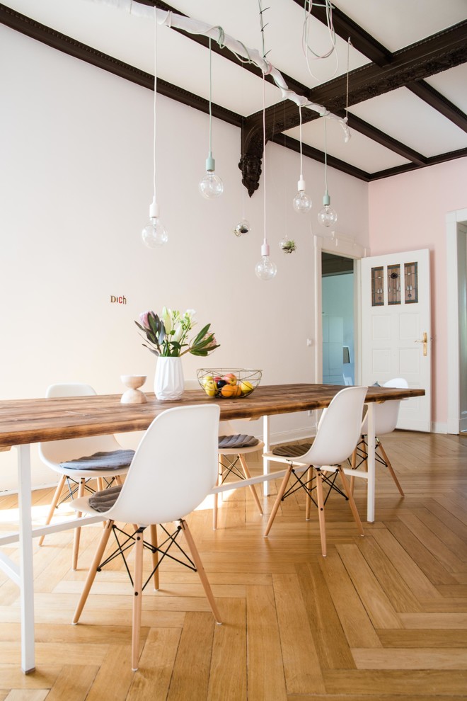 Example of a large minimalist light wood floor dining room design in Berlin with white walls