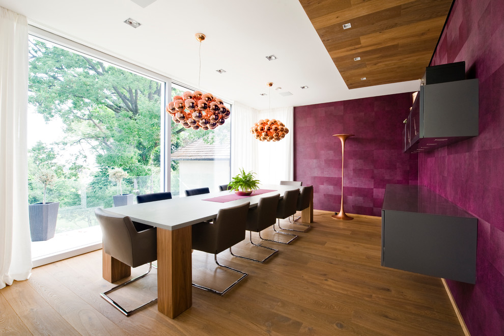 Geschlossenes, Mittelgroßes Modernes Esszimmer mit rosa Wandfarbe, braunem Holzboden und braunem Boden in Sonstige