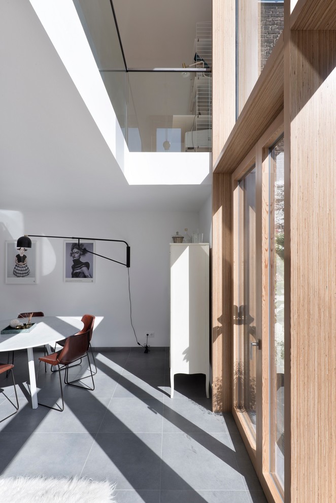 Idee per una sala da pranzo aperta verso il soggiorno contemporanea di medie dimensioni con pareti bianche, nessun camino e pavimento grigio