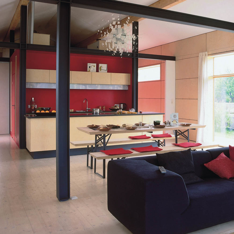 Esempio di una piccola sala da pranzo aperta verso la cucina contemporanea con pareti rosse e parquet chiaro