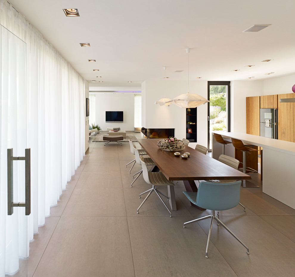 Пример оригинального дизайна: большая кухня-столовая в стиле модернизм с белыми стенами, двусторонним камином, фасадом камина из штукатурки и полом из линолеума