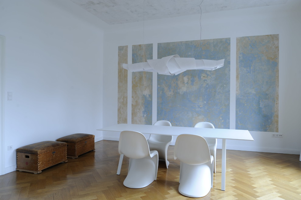 Exemple d'une grande salle à manger éclectique avec parquet clair et un mur blanc.