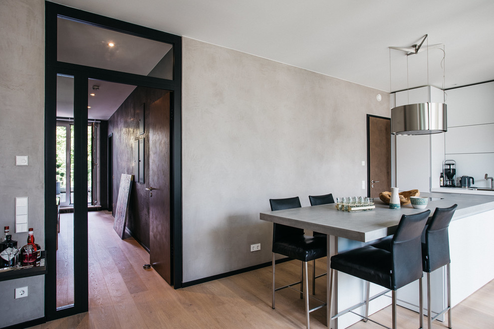 Mittelgroße Moderne Wohnküche ohne Kamin mit beiger Wandfarbe, hellem Holzboden und beigem Boden in Hamburg