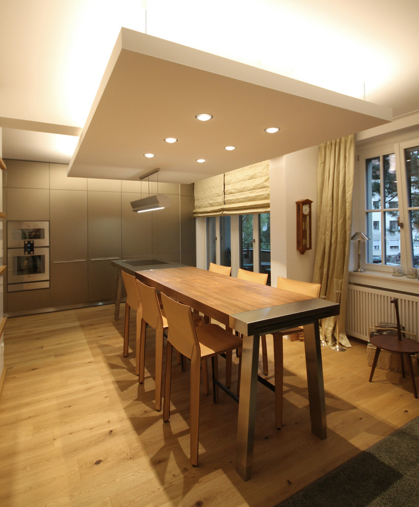 Пример оригинального дизайна: кухня-столовая среднего размера в современном стиле с белыми стенами, паркетным полом среднего тона и коричневым полом