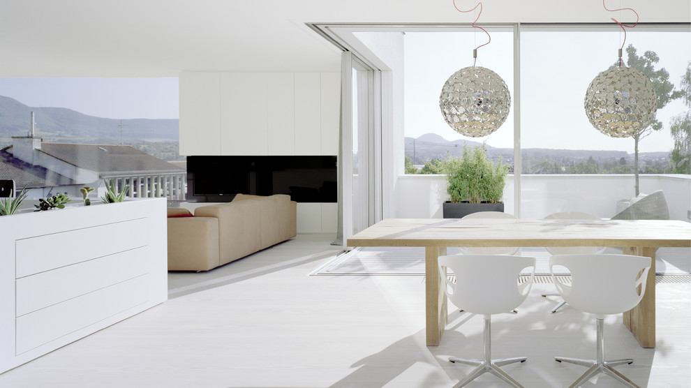 Idee per un'ampia sala da pranzo aperta verso il soggiorno minimal con pareti bianche e parquet chiaro