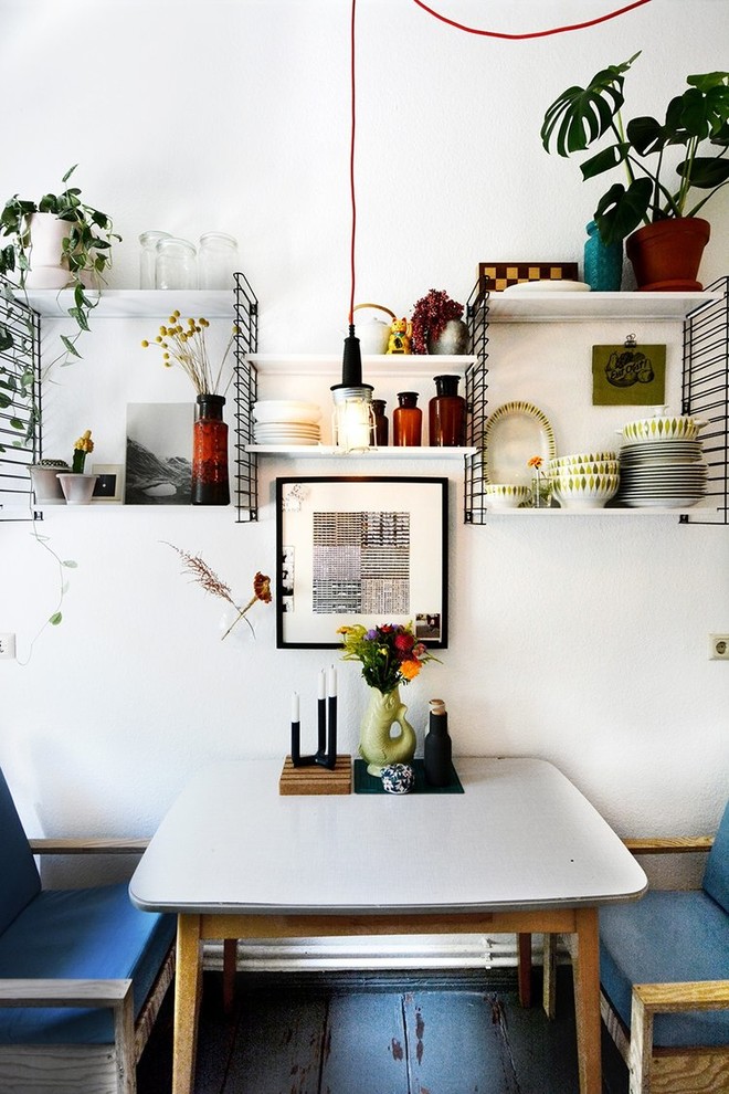 Cette photo montre une petite salle à manger éclectique avec un mur blanc et un sol gris.