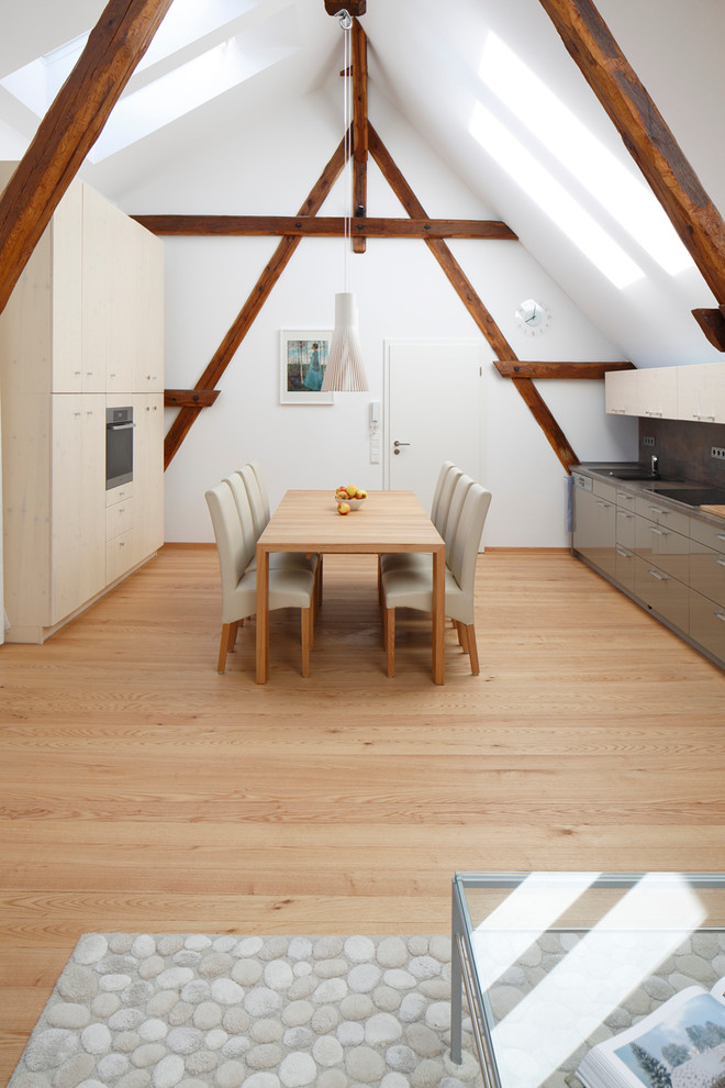 Diseño de comedor contemporáneo grande abierto con suelo de madera clara y paredes blancas