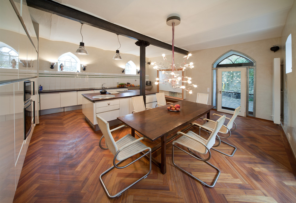 Idee per una grande sala da pranzo aperta verso il soggiorno mediterranea con pareti beige e pavimento in legno massello medio