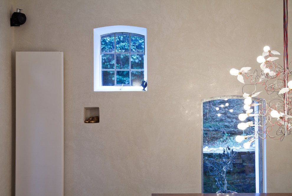 Immagine di una grande sala da pranzo aperta verso il soggiorno mediterranea con pareti beige e pavimento in legno massello medio