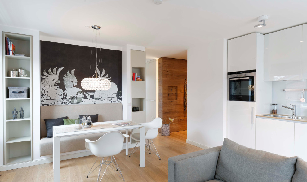 Offenes Modernes Esszimmer mit weißer Wandfarbe, braunem Holzboden und braunem Boden in Sonstige