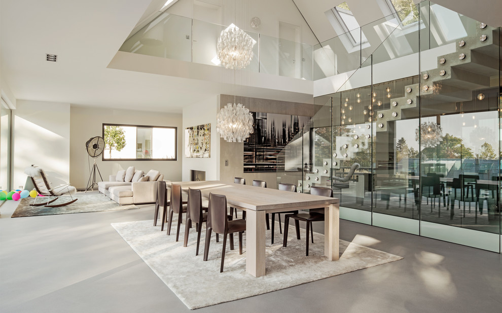 Photo of a large contemporary open plan dining room in Frankfurt with white walls, concrete flooring and grey floors.