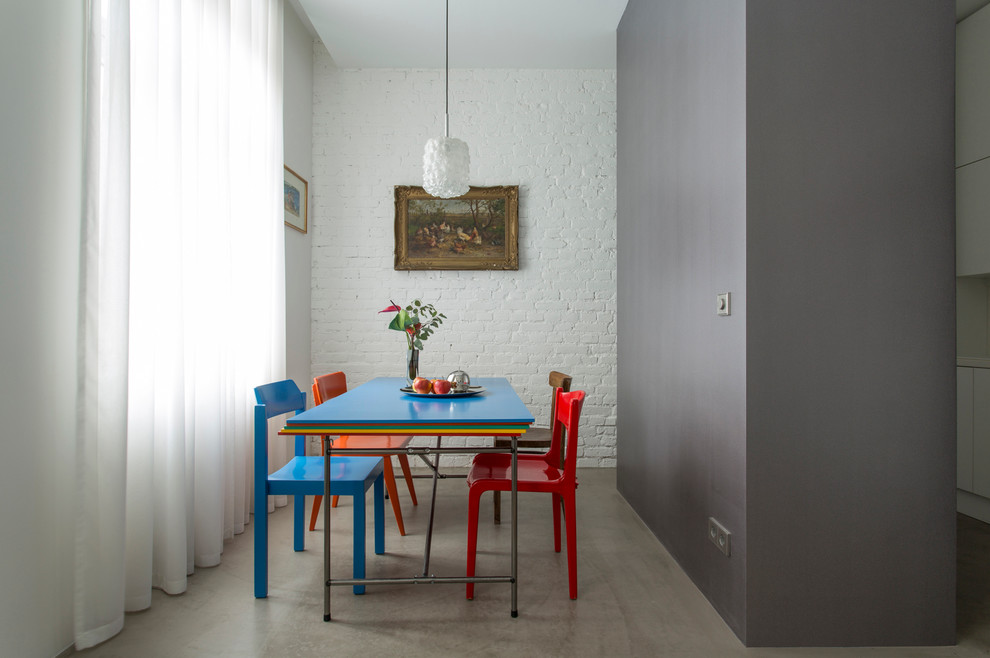 Esempio di una piccola sala da pranzo aperta verso il soggiorno minimal con pavimento in cemento e pareti grigie