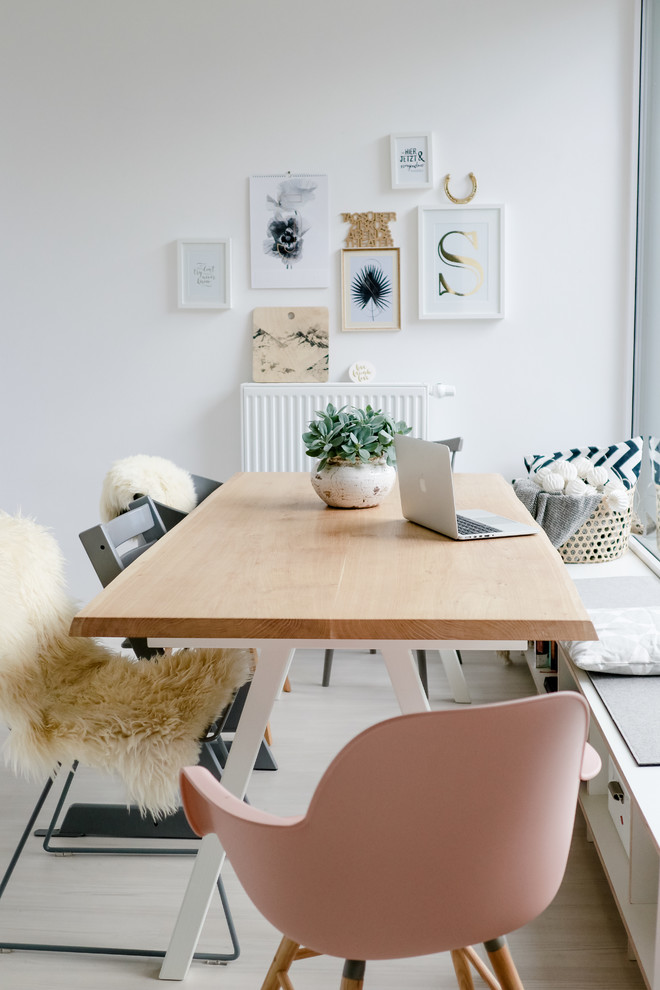 Immagine di una sala da pranzo nordica con pareti bianche, parquet chiaro e pavimento beige