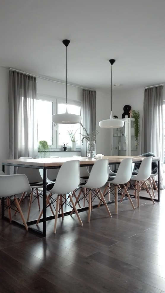 На фото: гостиная-столовая среднего размера в скандинавском стиле с белыми стенами и коричневым полом без камина с