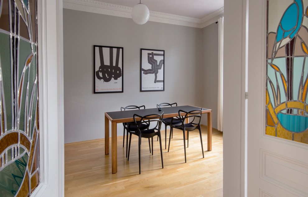 Inredning av en minimalistisk mellanstor matplats med öppen planlösning, med grå väggar, mellanmörkt trägolv och brunt golv