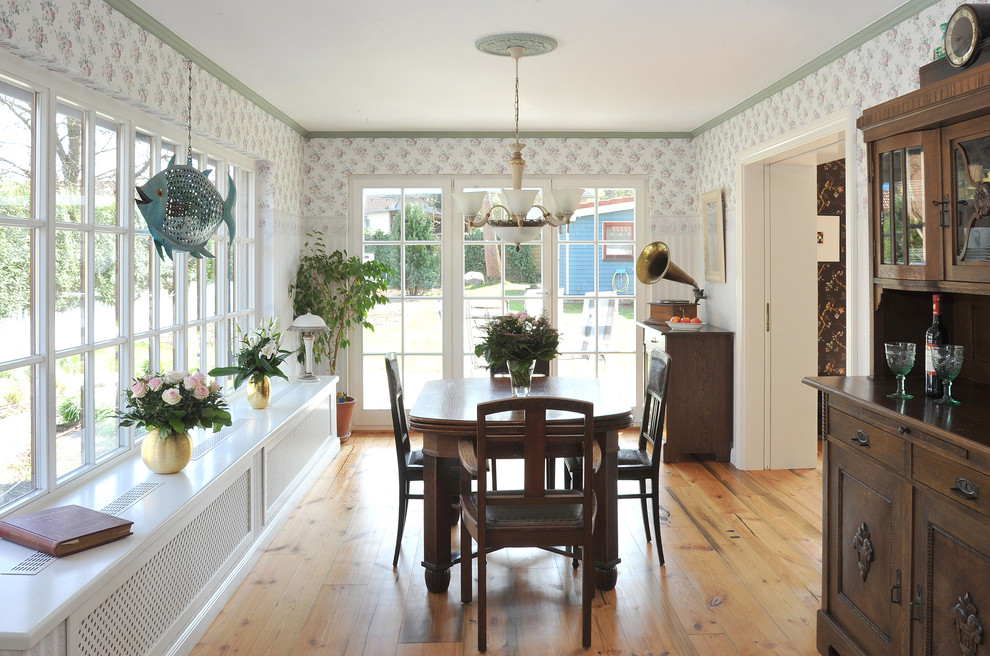 Foto de comedor de estilo de casa de campo de tamaño medio abierto sin chimenea con suelo de madera clara y paredes multicolor