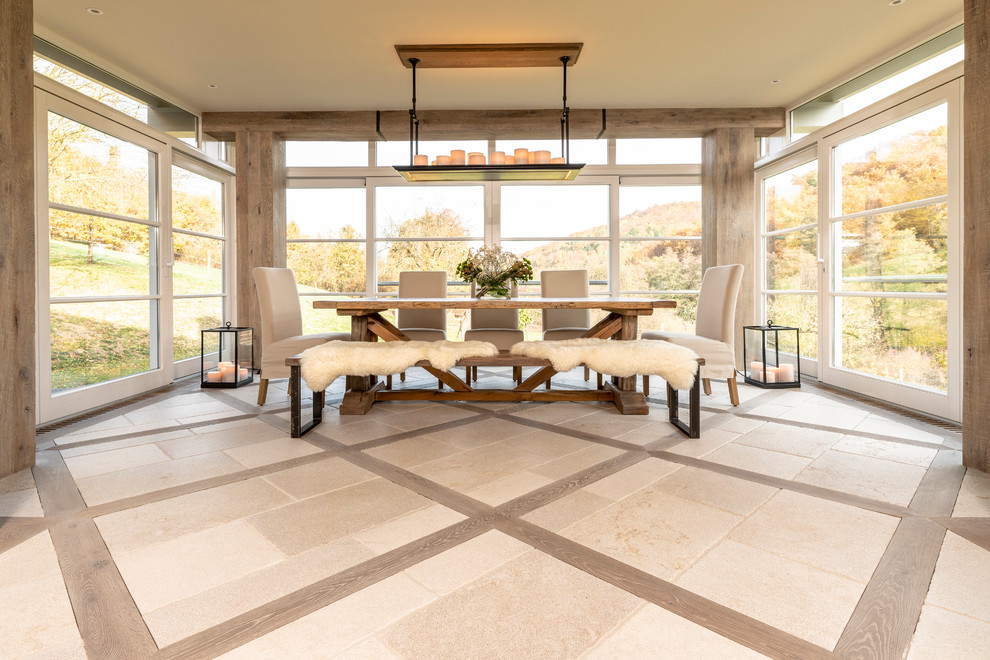 Ispirazione per una grande sala da pranzo aperta verso il soggiorno country con pareti beige, pavimento in pietra calcarea e pavimento beige