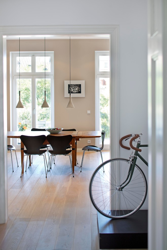 Exemple d'une salle à manger ouverte sur le salon tendance de taille moyenne avec un mur beige, parquet clair et un sol marron.
