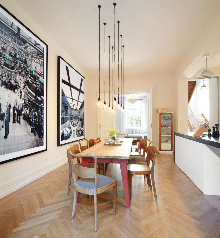 Immagine di una sala da pranzo aperta verso la cucina nordica con pareti bianche e parquet chiaro