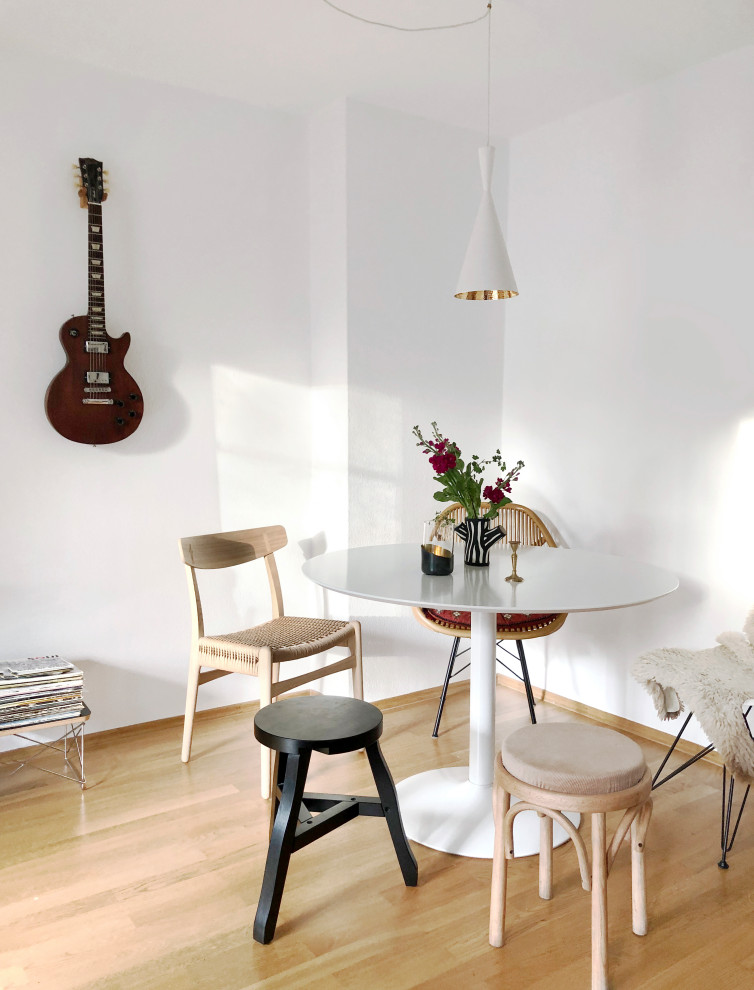 Inspiration pour une petite salle à manger ouverte sur le salon design avec un mur blanc, parquet clair, aucune cheminée et un sol marron.
