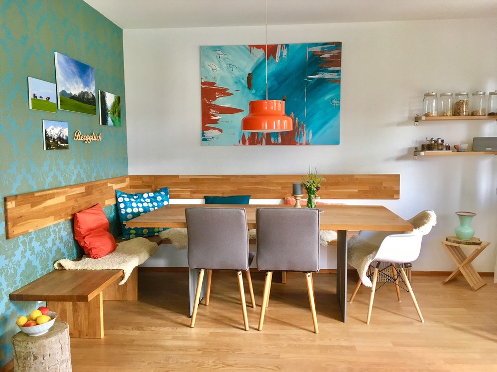 Immagine di una sala da pranzo aperta verso la cucina boho chic di medie dimensioni con pareti blu, pavimento in legno massello medio, pavimento marrone e nessun camino