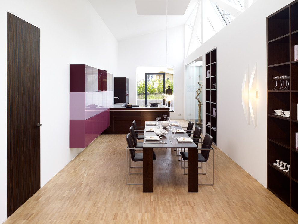 Ispirazione per una sala da pranzo aperta verso la cucina design di medie dimensioni con pareti bianche e pavimento in bambù