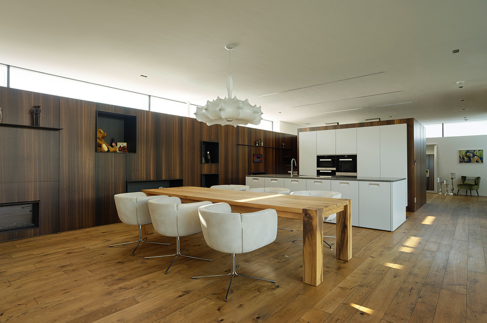 Moderne Wohnküche mit braunem Holzboden in Sonstige