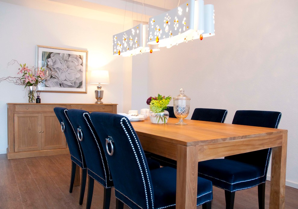 Foto di una sala da pranzo aperta verso il soggiorno bohémian di medie dimensioni con pareti bianche, pavimento in vinile e pavimento marrone