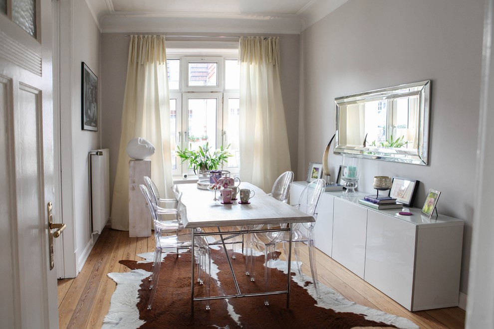 Medium sized bohemian enclosed dining room in Hamburg with grey walls and medium hardwood flooring.