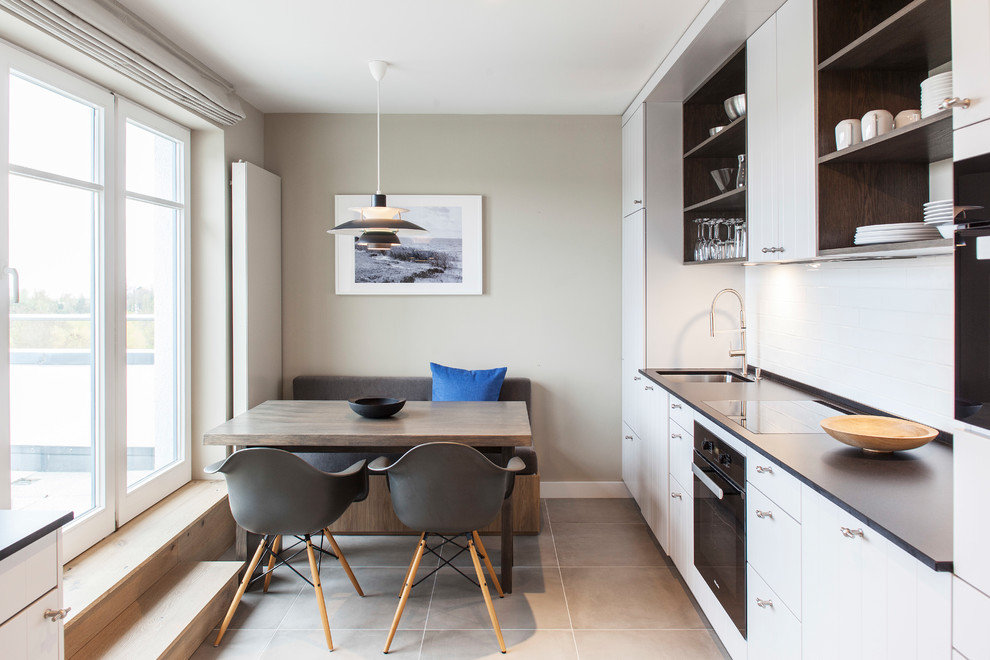 Foto di una piccola sala da pranzo aperta verso la cucina scandinava con pavimento grigio e pareti beige