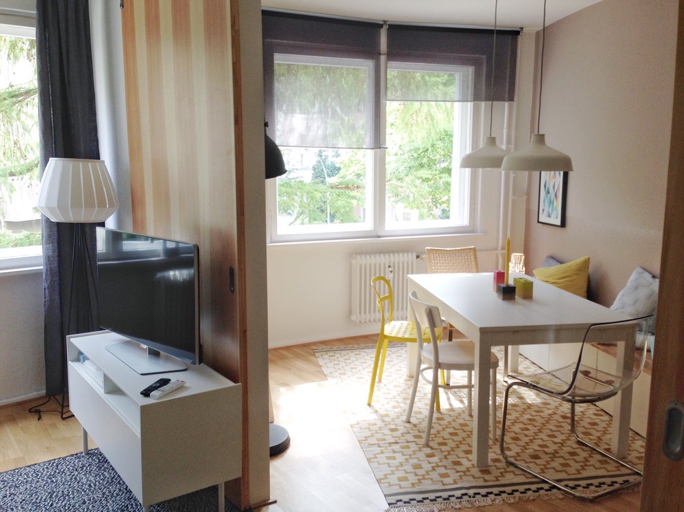 Small scandi open plan dining room in Berlin with medium hardwood flooring and beige walls.